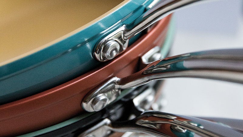 一堆蓝色、红色和绿色的煎锅，采用 品牌 不粘技术涂层。