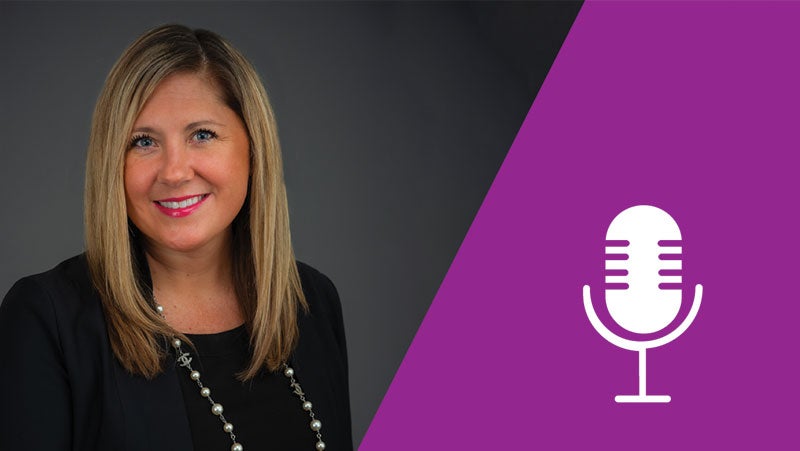 品牌 全球粉体业务总监 Courtney Jungjohann Deemer 在灰色背景前微笑。